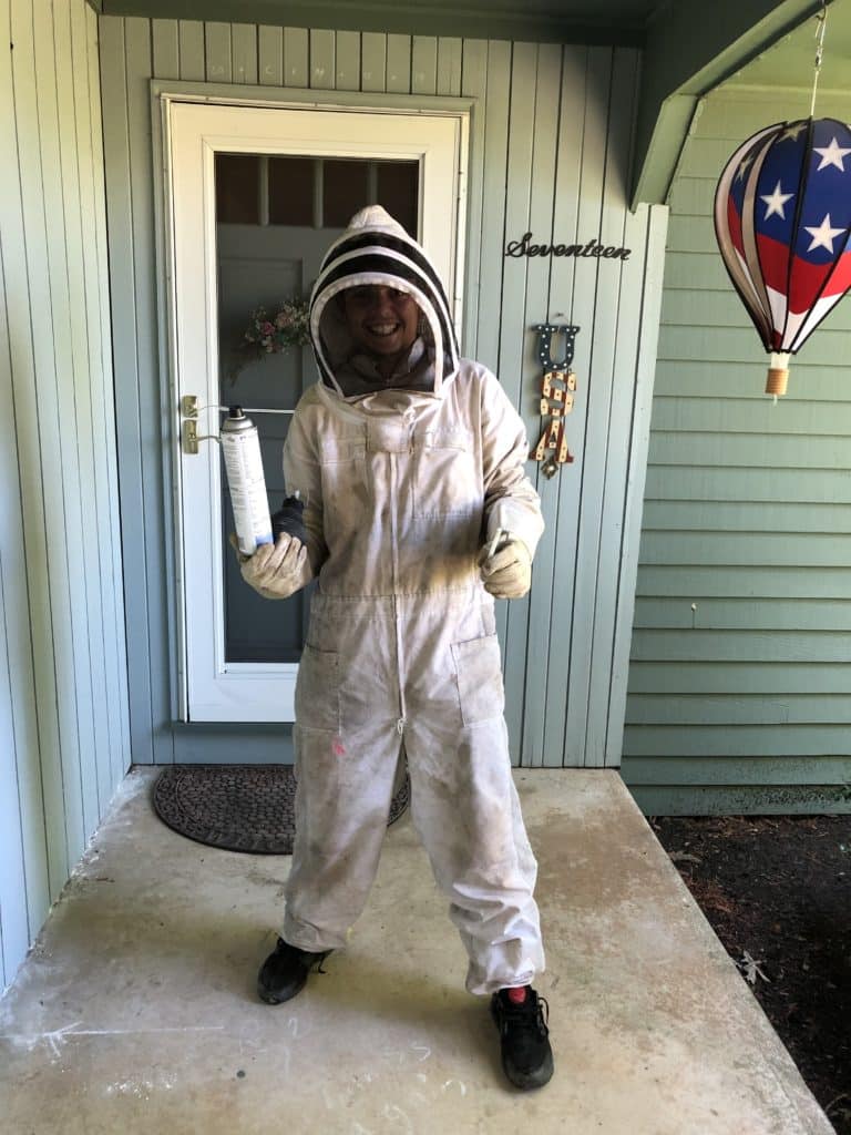 A boy in a wasp suit standing on a porch.